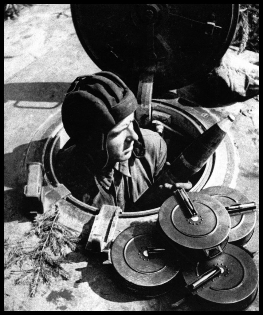 Crewman of a Russian KV-1 Tank taking on ammunition for the 76mm main gun and 7.6mm ammo drums for the DT machine gun